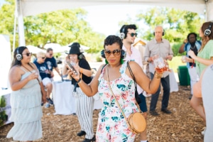 Woman in the foreground dancing at the Silent Disco at Taste of Sonoma with other dancers in the background